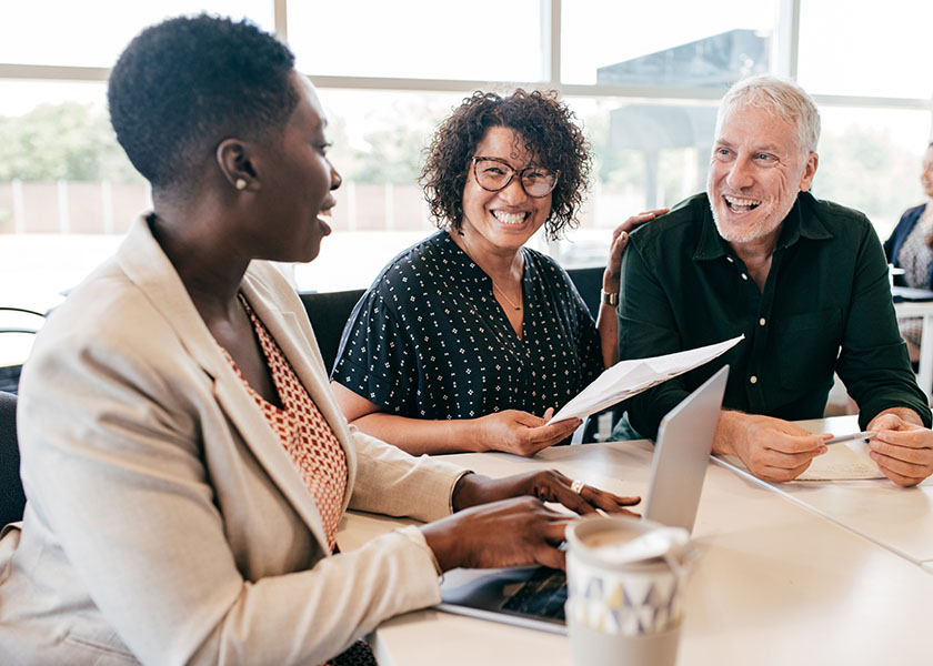 Smiling couple talking to financial advisor